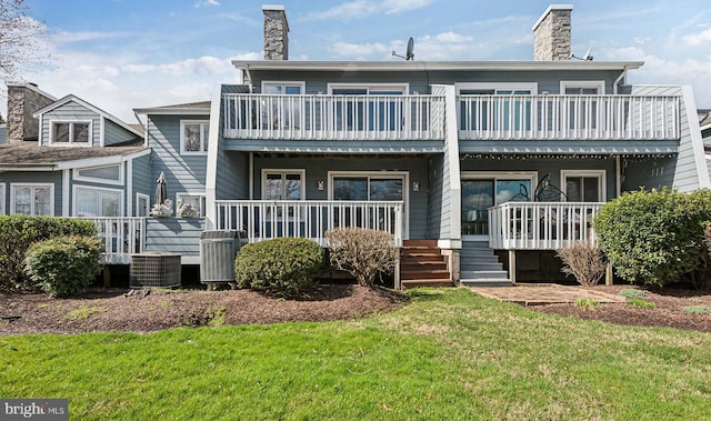 back of house featuring a yard, central AC unit, covered porch, and a chimney