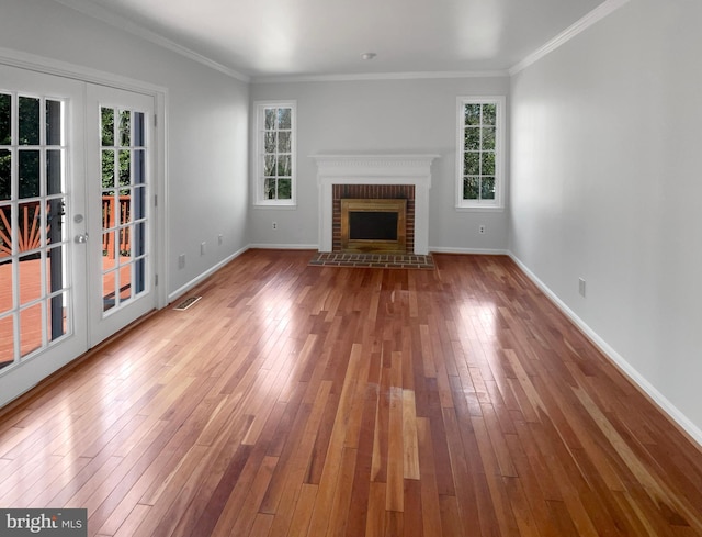 unfurnished living room featuring baseboards, visible vents, and wood-type flooring