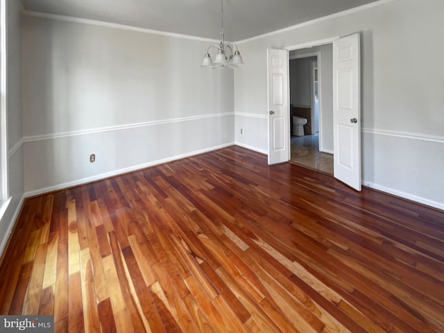 unfurnished dining area with baseboards, an inviting chandelier, wood finished floors, and crown molding