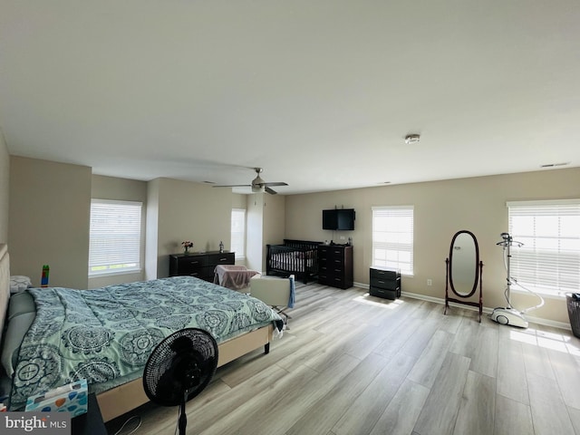 bedroom with light wood finished floors, ceiling fan, and baseboards