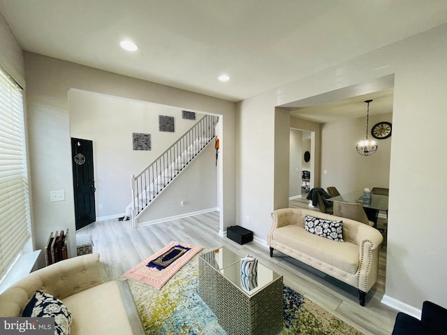 living area with a notable chandelier, stairway, recessed lighting, and wood finished floors