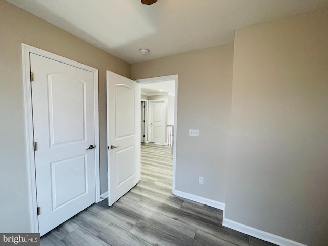 unfurnished bedroom featuring baseboards and wood finished floors