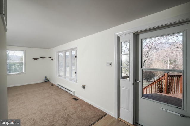 carpeted foyer with visible vents, baseboards, and a baseboard radiator