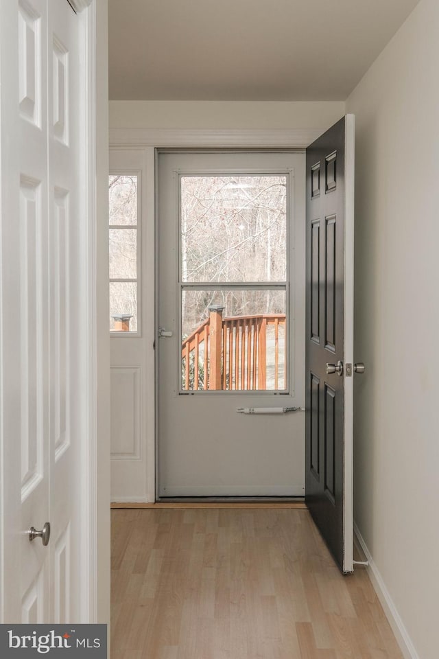 entryway featuring baseboards and light wood-style floors