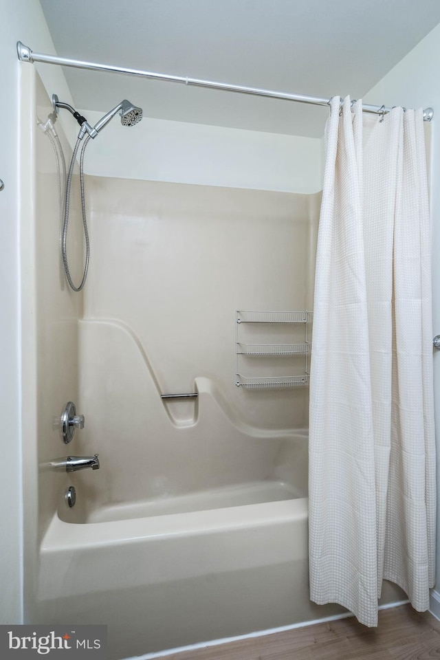 full bath with shower / tub combo and wood finished floors