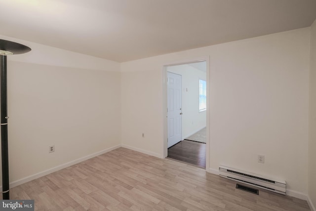 unfurnished room with a baseboard radiator, baseboards, light wood-style floors, and visible vents