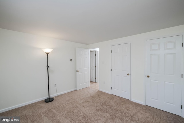 unfurnished bedroom with carpet flooring and baseboards