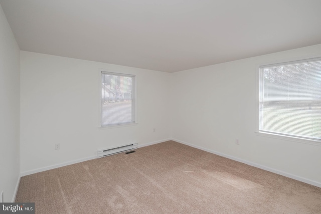 carpeted spare room with a baseboard heating unit and baseboards