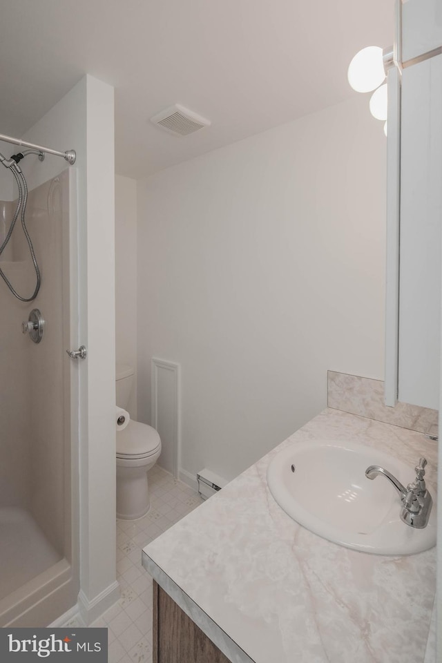 bathroom featuring vanity, toilet, visible vents, and walk in shower