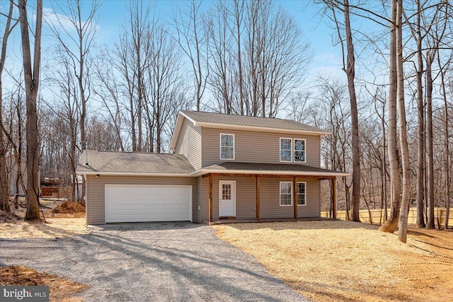 view of front of property with an attached garage and gravel driveway