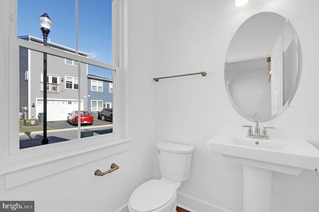 bathroom with a sink, baseboards, and toilet