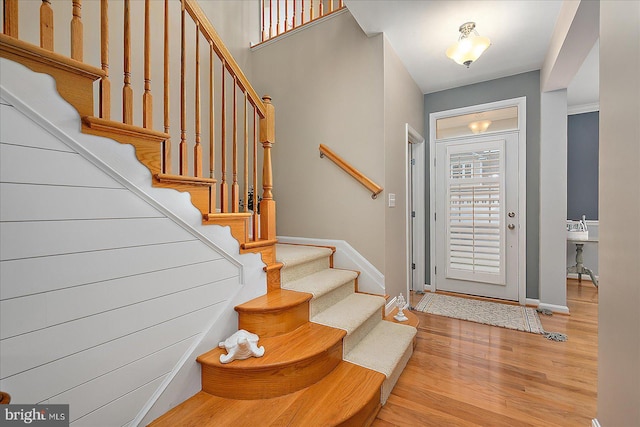 entrance foyer with stairway, baseboards, and wood finished floors