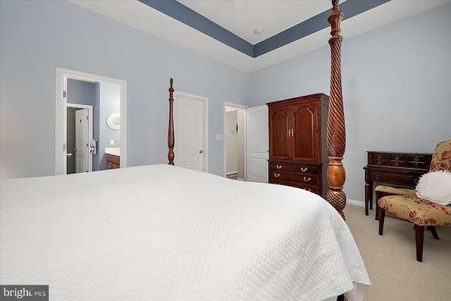 bedroom featuring light colored carpet, baseboards, and connected bathroom