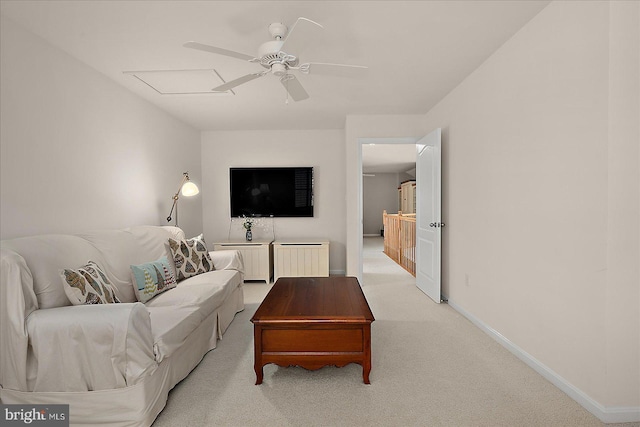 living room featuring ceiling fan, baseboards, and light carpet