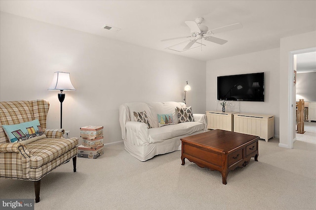 living room with visible vents, baseboards, light colored carpet, and ceiling fan