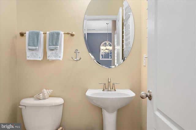 bathroom featuring a chandelier and toilet