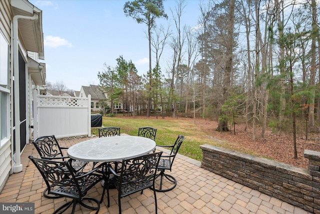 view of patio featuring outdoor dining space and fence