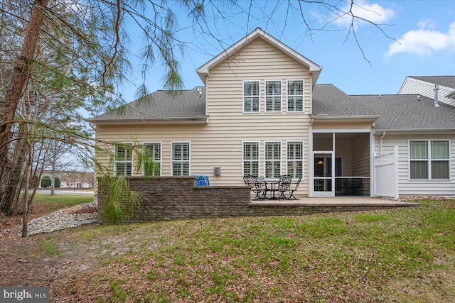 back of property featuring a yard, a patio area, and a shingled roof