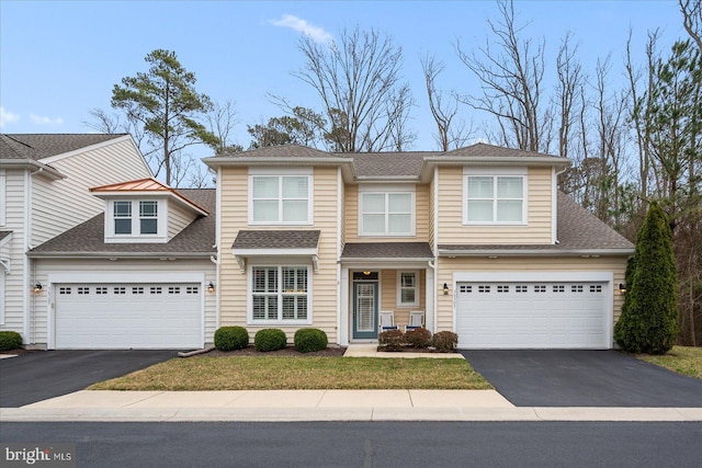 view of front of house with a garage, driveway, and roof with shingles