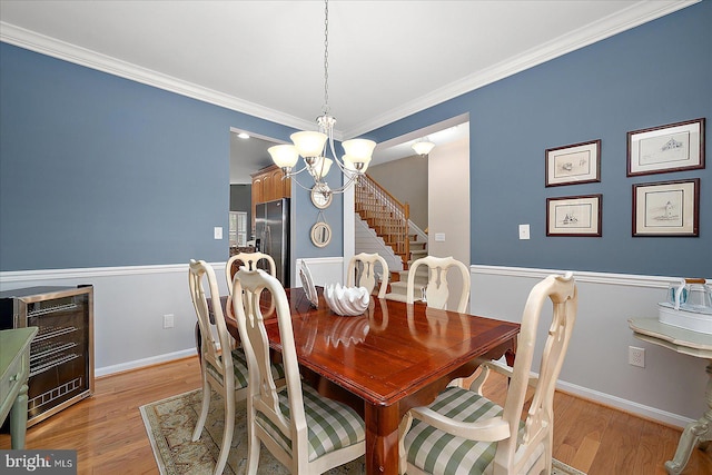 dining space featuring a chandelier, light wood-style flooring, and baseboards