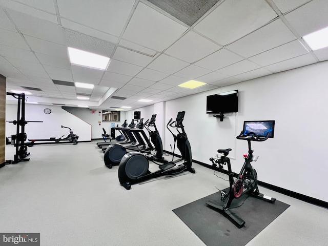 gym featuring visible vents, a paneled ceiling, and baseboards