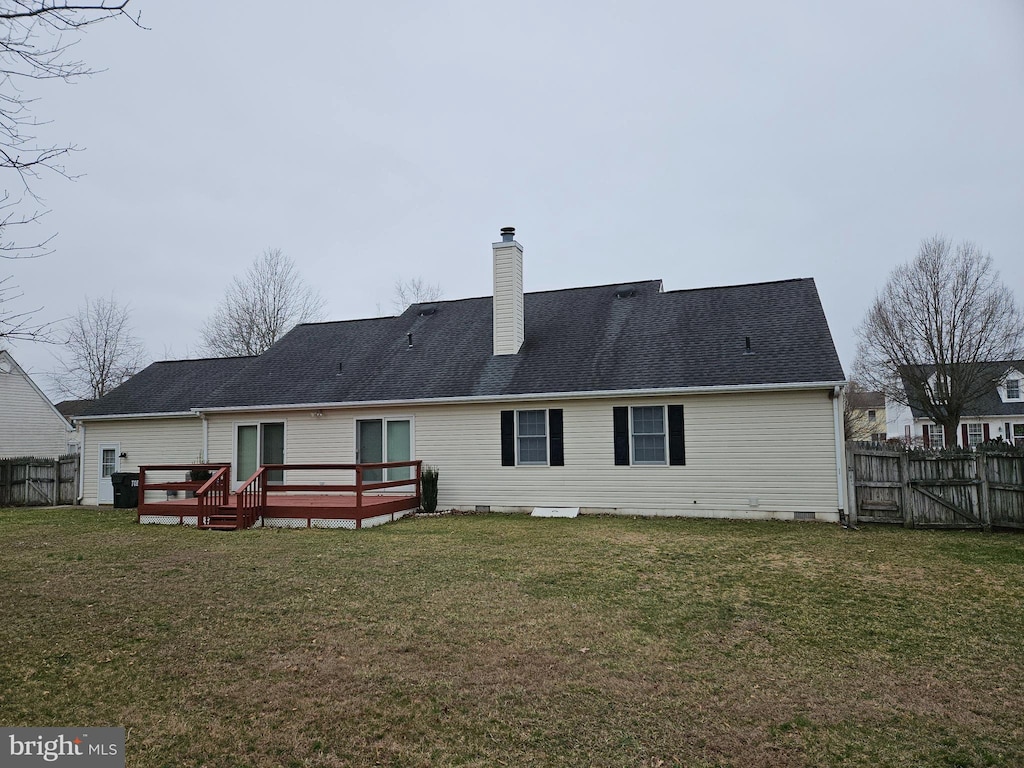 back of house with crawl space, a lawn, a chimney, and fence