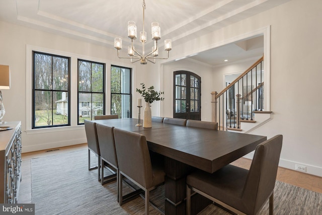 dining area with baseboards, a raised ceiling, an inviting chandelier, and visible vents