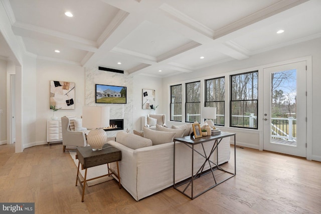 living room with beam ceiling, coffered ceiling, a fireplace, and light wood-type flooring