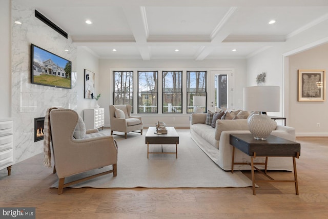 living area with a high end fireplace, beamed ceiling, recessed lighting, wood finished floors, and coffered ceiling