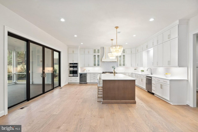 kitchen featuring beverage cooler, visible vents, a sink, custom range hood, and appliances with stainless steel finishes