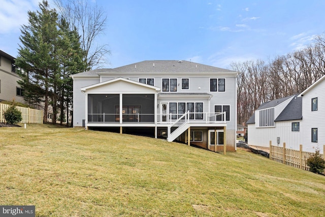 rear view of property with stairway, fence, a lawn, and a sunroom