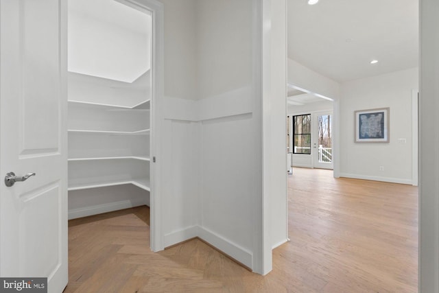 interior space with parquet floors, recessed lighting, and baseboards