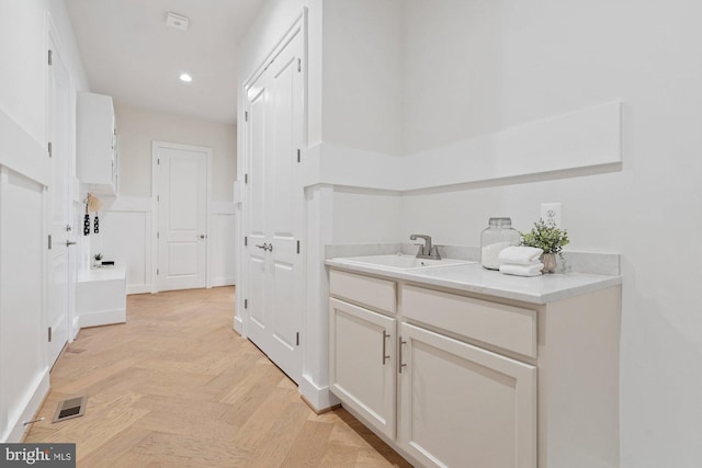 bathroom featuring a sink, visible vents, and recessed lighting