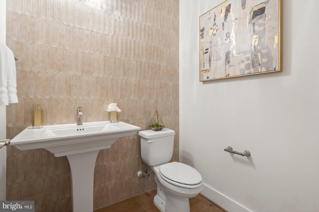 half bath with toilet and baseboards