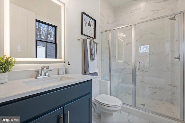 bathroom featuring vanity, toilet, marble finish floor, and a marble finish shower