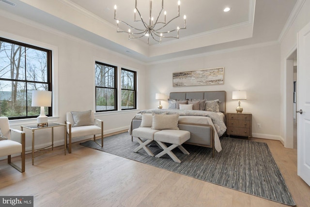 bedroom featuring a tray ceiling, a notable chandelier, wood finished floors, and ornamental molding