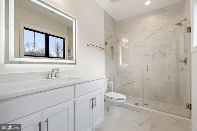 bathroom with a marble finish shower, toilet, recessed lighting, marble finish floor, and vanity