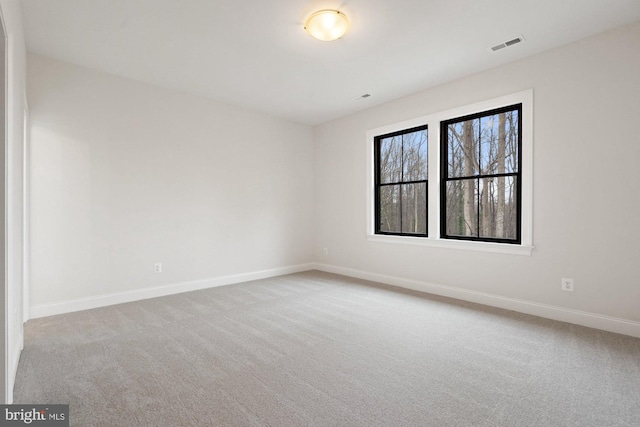 unfurnished room with visible vents, carpet, and baseboards