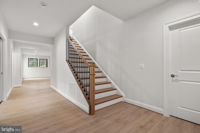 staircase featuring recessed lighting, visible vents, baseboards, and wood finished floors