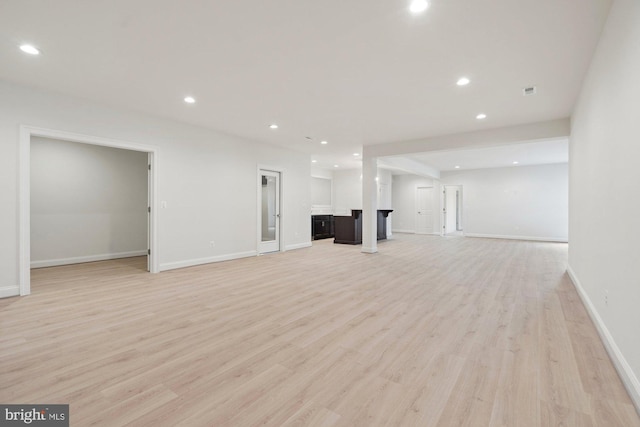 unfurnished living room featuring light wood-style flooring, recessed lighting, and baseboards