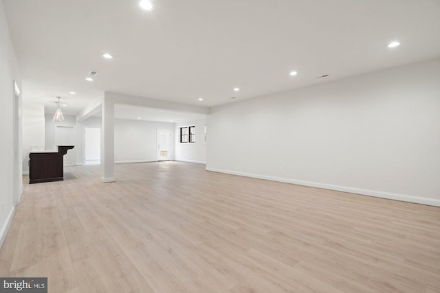 unfurnished living room with light wood-style flooring, recessed lighting, and baseboards