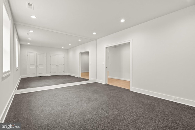 spare room with recessed lighting, visible vents, baseboards, and dark carpet