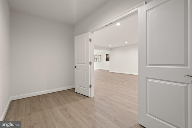 empty room featuring recessed lighting, baseboards, and wood finished floors