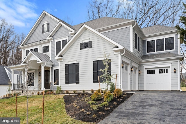 view of front of house featuring aphalt driveway, a garage, roof with shingles, and a front yard