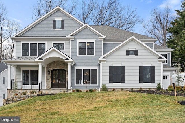 view of front facade featuring stone siding, french doors, and a front yard