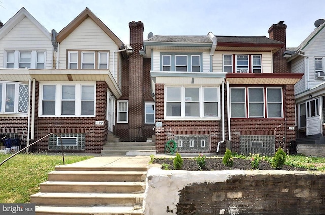 multi unit property with brick siding and a chimney