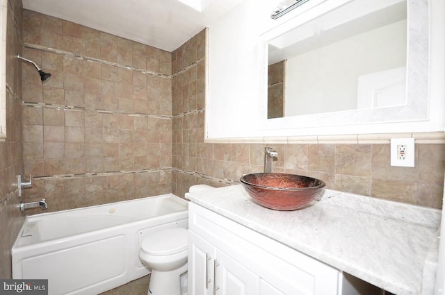 bathroom featuring toilet, tile walls, vanity, and washtub / shower combination