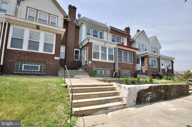 townhome / multi-family property featuring brick siding and a chimney