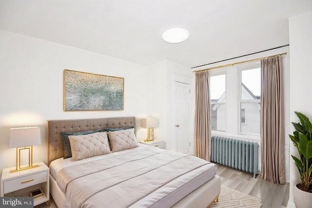 bedroom featuring light wood-style flooring and radiator heating unit