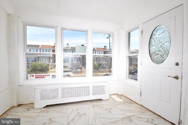 unfurnished sunroom with radiator heating unit